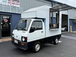 Small cream Kei truck with a compact box and single service window