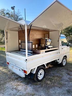 White Kei truck with a full canopy awning open over the bed