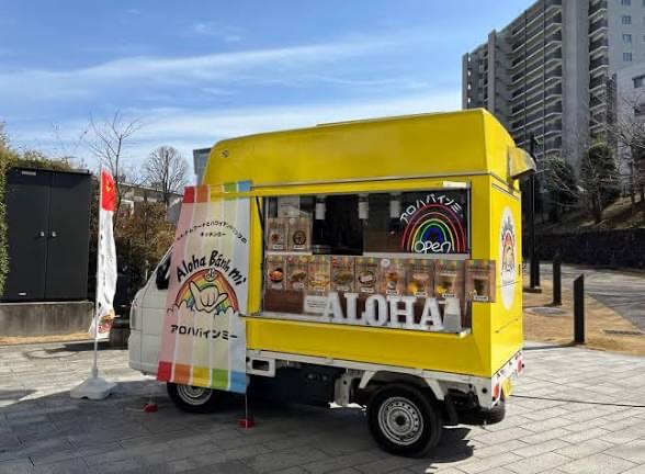 Bright yellow Kei truck branded Aloha, colorful wrap