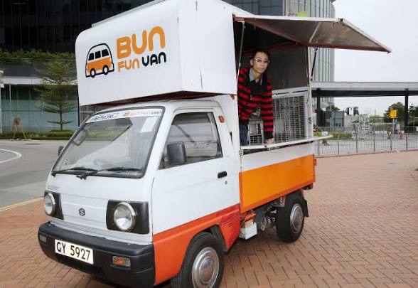 White and orange Kei truck branded Bun Fun Van, vendor leaning out the window