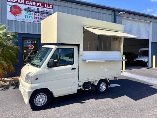 Cream Kei truck box with a drop-down awning window open