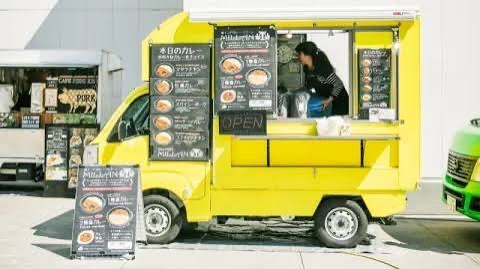 Yellow Kei truck with chalkboard menus flanking the service window